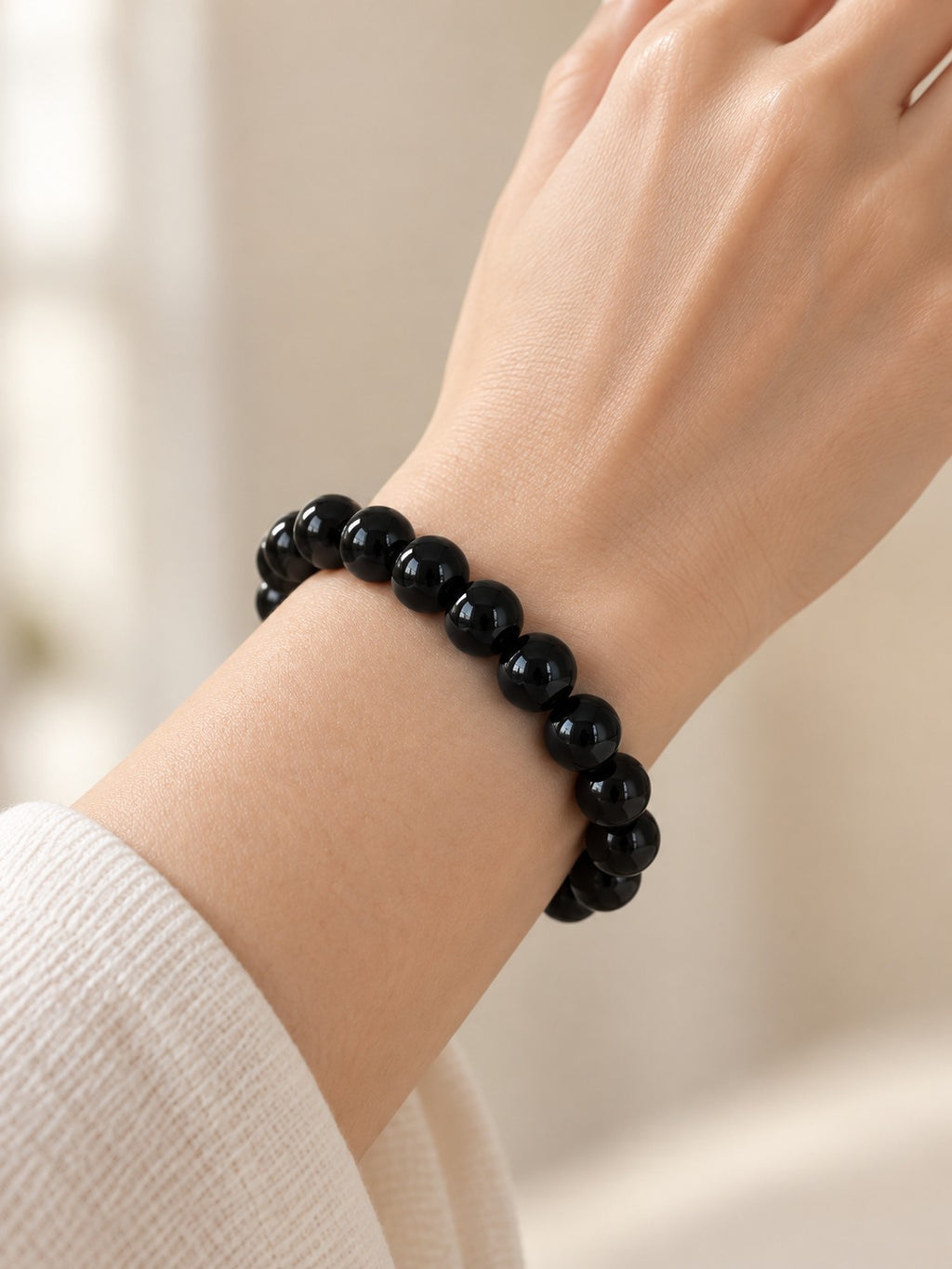 Jet Black 10.3 mm Obsidian Bracelet (#B905) worn on a wrist