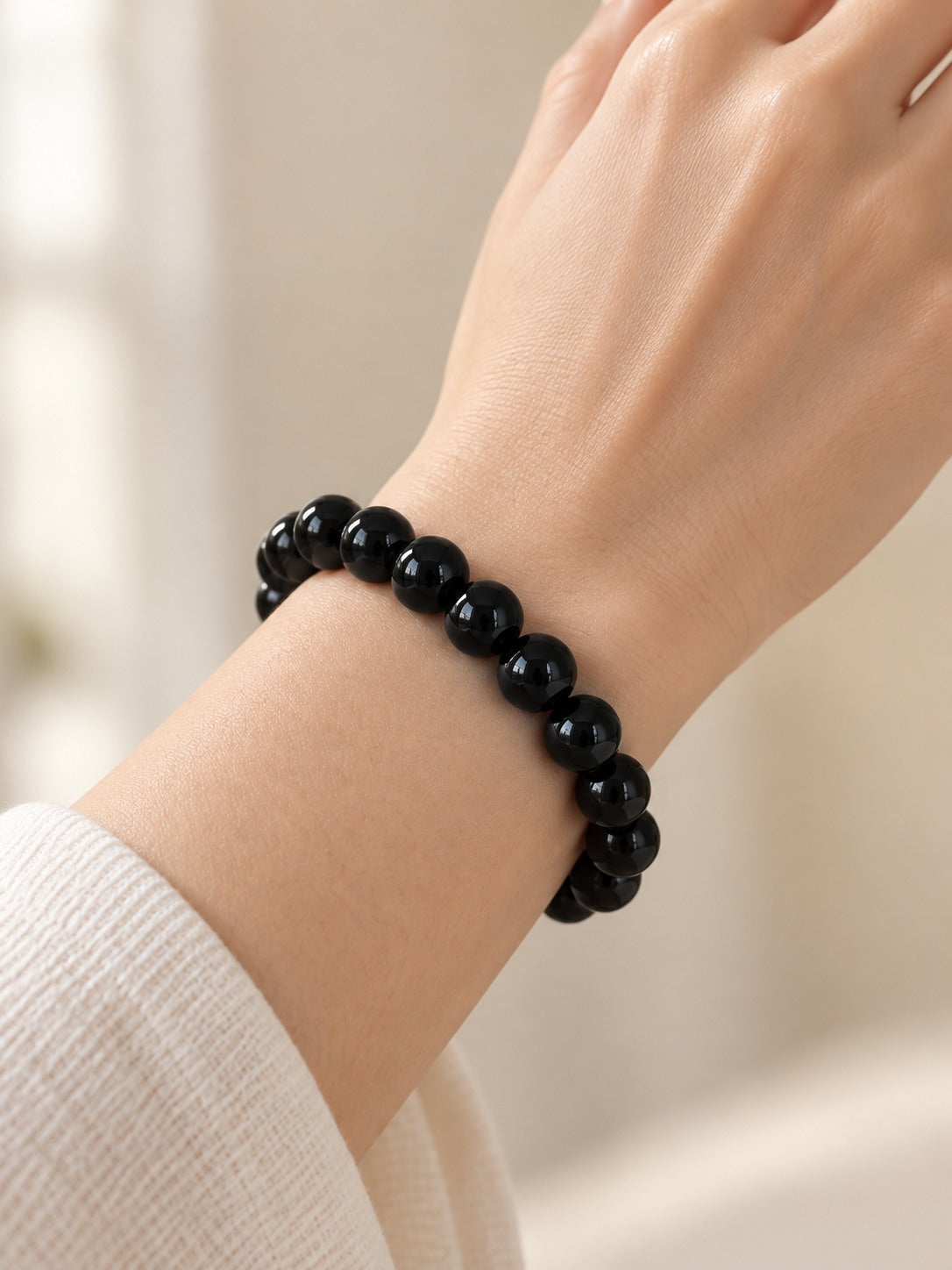 Jet Black 10.3 mm Obsidian Bracelet (#B905) worn on a wrist